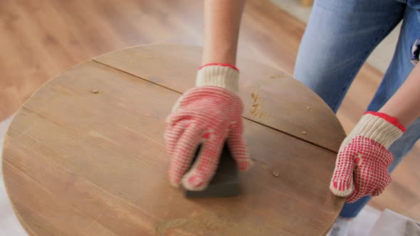 Woman Sanding Old Round Wooden Table with Sponge