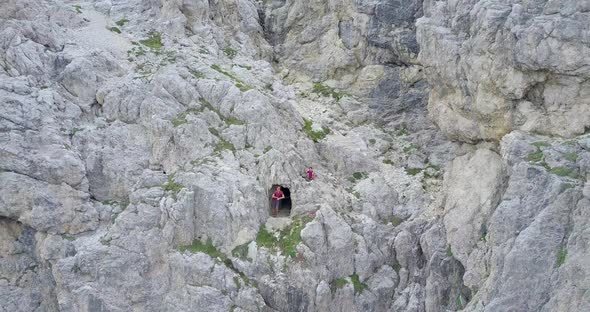 Aerial drone view of a cave and hiking in the mountains.