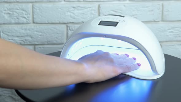 Woman use UV lamp for nails.