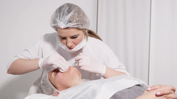 Doctor Beautician Pricks the Patient's Face