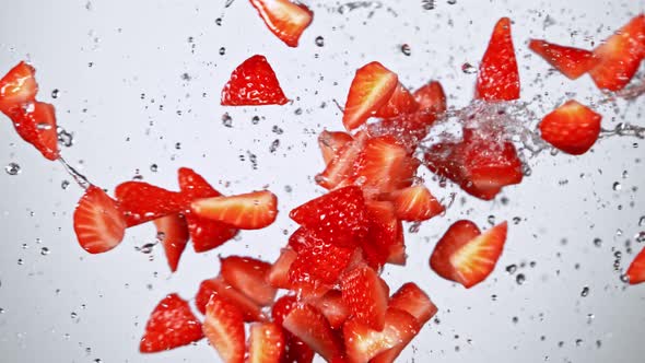 Super Slow Motion Shot of Fresh Strawberries and Water Side Collision on White at 1000Fps