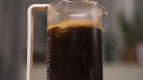 Stirring coffee grounds in a french press.