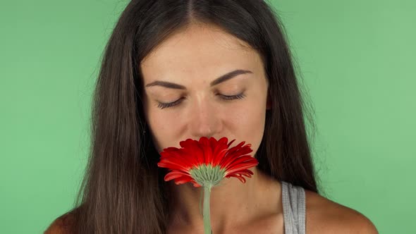 Young Beautiful Woman Smelling Red Flower on Chromakey Green Background