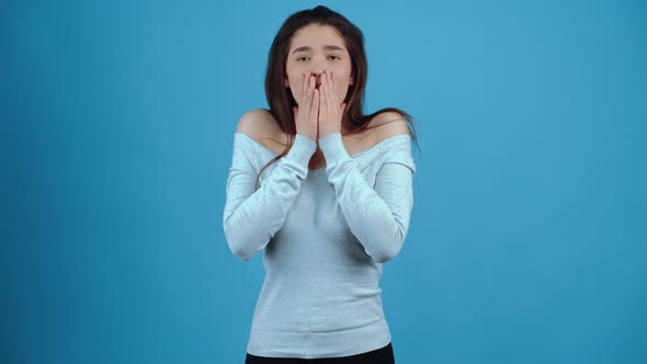 The Frightened Girl Puts Her Palms to Her Lips and Makes Her Eyes Look Shocked