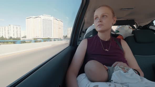 Mom with Baby Traveling By Car in the City