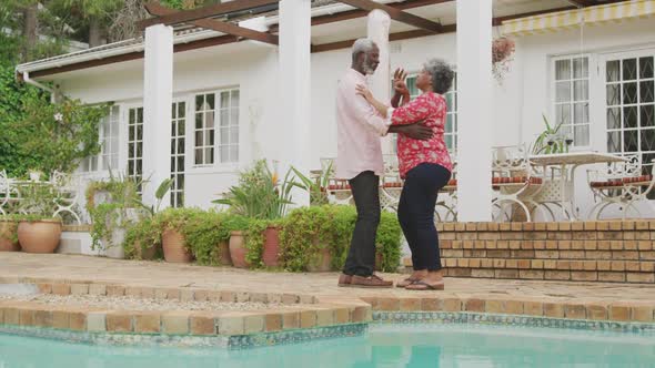 A senior african american couple spending time together dancing in the garden social distancing in q