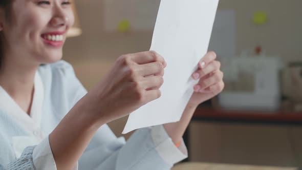 Close Up Of Asian Woman Designer Positively Shaking Her Head While Looking At The Layout Bond