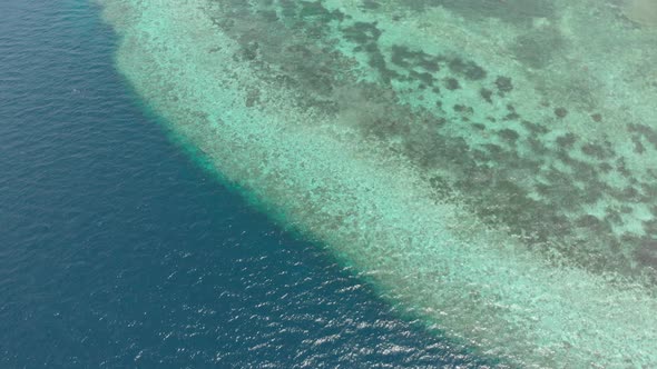 Aerial: Flying over tropical beach turquoise water coral reef , Tomia island Wak