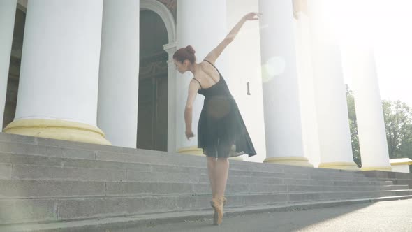 Back View of Slim Ballet Dancer on Tiptoes Dancing in Sunrays Outdoors