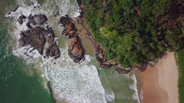 Aerial Top view Waves Break On Dark Rocks Near Beach. Sri Lanka