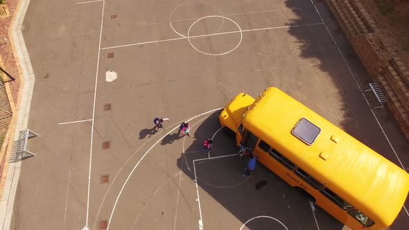 Teacher giving high to kids while entering in bus