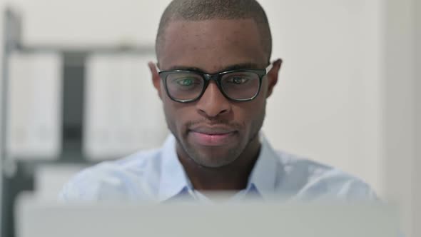 Close Up of African Man Doing Thumbs Up with Laptop