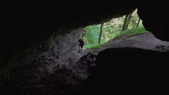 Hiker walking in a cave. People in nature concept.