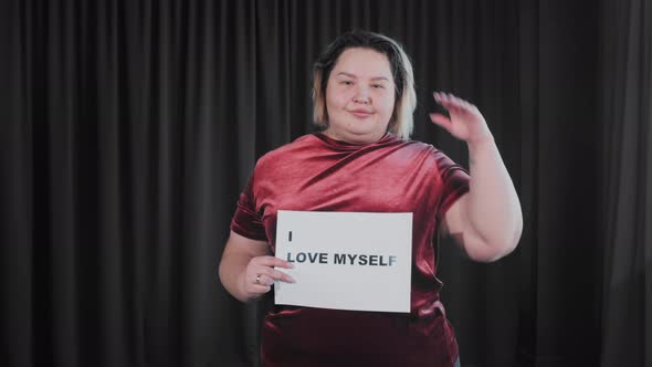 A Confident Flirty Fat Woman Holding a Nameplate with a Sign I LOVE MYSELF