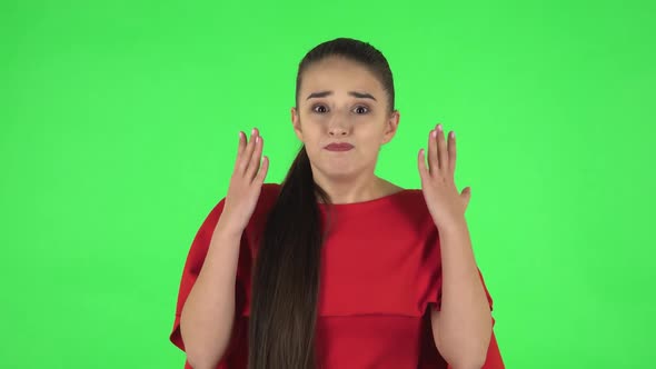 Portrait of Pretty Young Displeased Woman Is Indignantly Talking To Someone. Green Screen