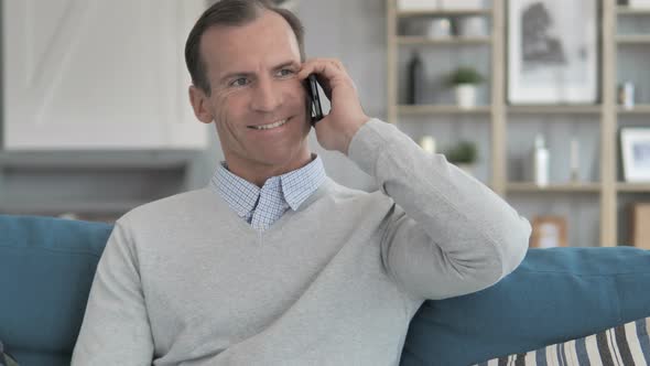 Relax Middle Aged Man Using Smartphone while Sitting on Couch