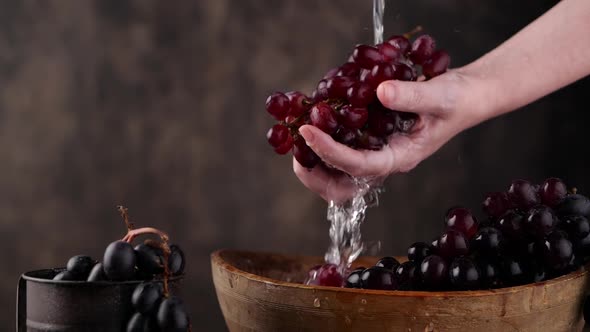 Crop Person Washing Ripe Grapes