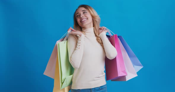 Excited Woman Carrying Shopping Bags and Dancing in Studio