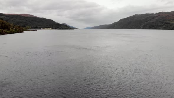Flying low over choppy Loch Ness water on gray day, Scotland, aerial