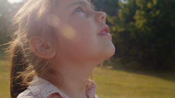 Portrait of a Cute Little Girl Looking Up at the Sky