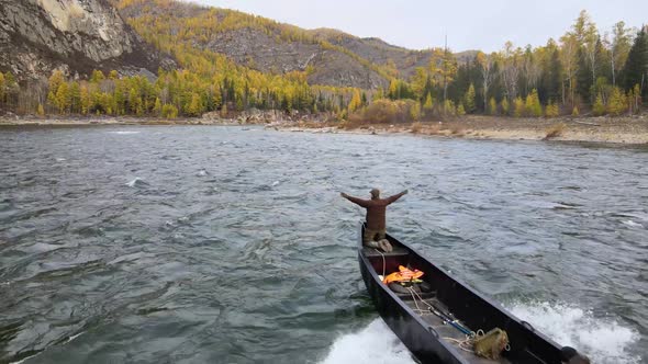 A Motor Boat Breaks Into the Frame Cutting Through the Waves of a Stormy Mountain River