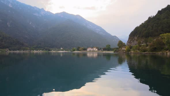 Aerial view on water of Ledro Lake. Drone on the water, beautiful cinematic shot, from Lake to town