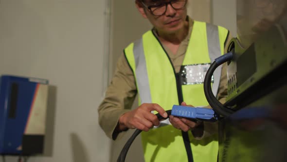 Asian male worker wearing safety suit with helmet in warehouse