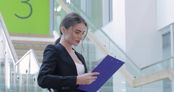 Business Woman With Folder In Hands In Office Building