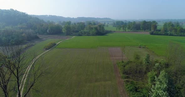 Moving Forward Over Green Fields and Gravel Paths in Summer Day