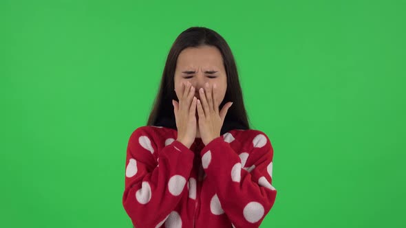 Portrait of Beautiful Girl in Red Fleece Pajamas Is Yawning, Bedtime Concept. Green Screen