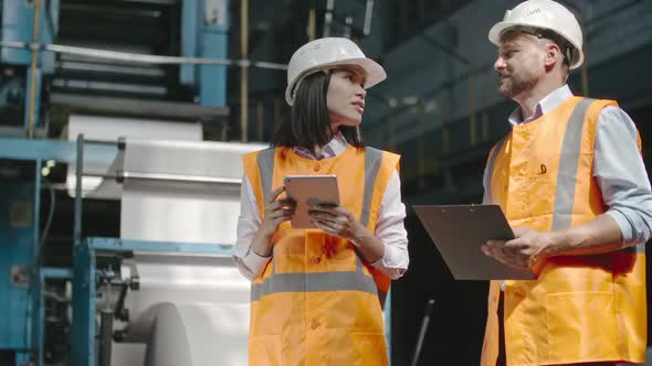 Male and Female Supervisors Inspecting Factory