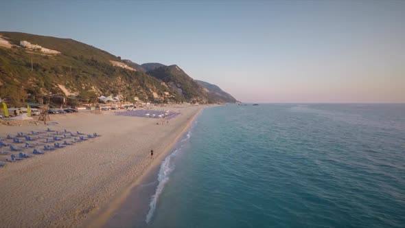 Aerial view of shore of the beach at sunset with few people in Lefkas island.