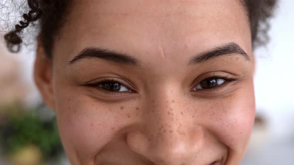 Closeup of an African American Millennial Curly Haired Girl Looking at the Camera Smiling