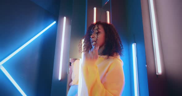 Wide Angle Positive African American Black Woman in Yellow Hoodie Dancing in Night Club Backlit with