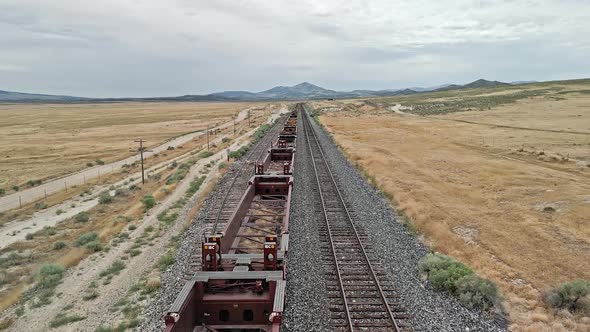 Flying over train tracks reaching across the desert landscape