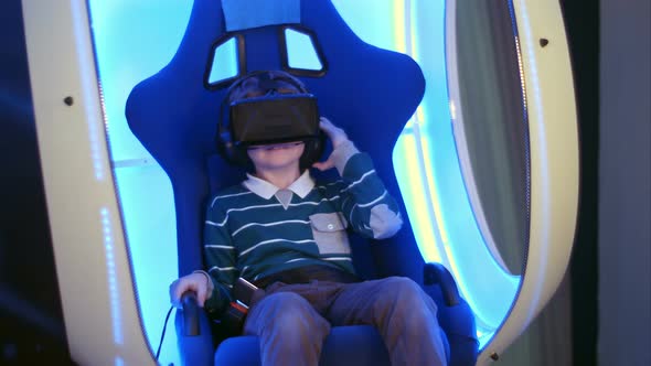 Surprised Little Boy Experiencing Virtual Reality in a Moving Interactive Chair