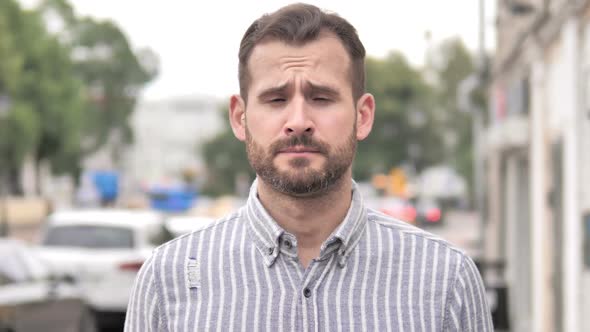 Outdoor Portrait of Upset Beard Casual Man