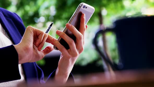 Female customer using mobile phone at counter