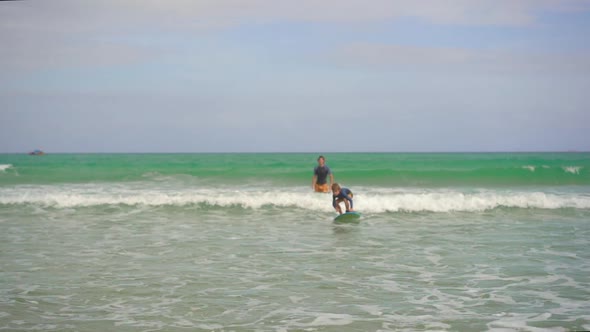 Surf Instructor Teaches Little Boy How To Surf