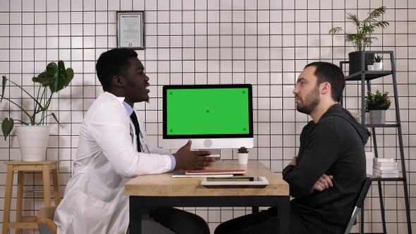 Doctor Showing Medical Records on His Computer to His Patient