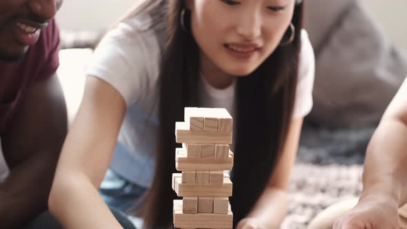 Young Multi Ethnic People Playing Jenga Game Indoors