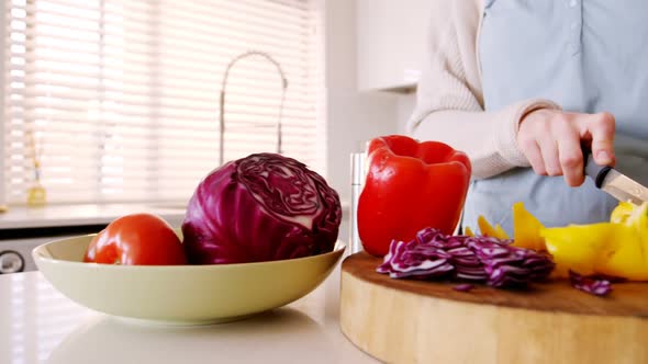Woman cutting vegetables in kitchen