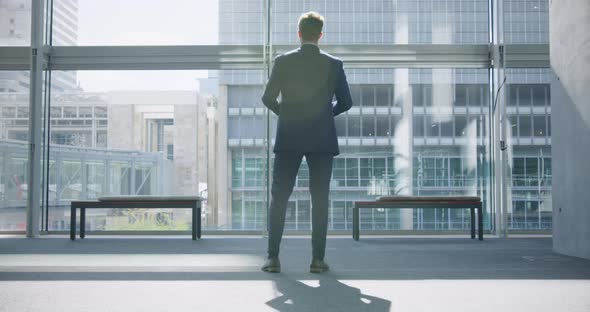 Businessman looking upwards in the lobby at office 4k