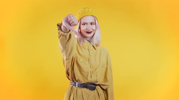 Young Pretty Woman Standing on Yellow Studio Background Expressing Discontent