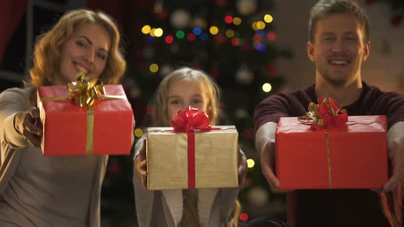 Smiling Parents and Daughter Showing Presents to Camera, Christmas Wish List