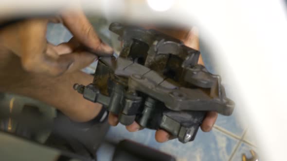 Close-up Footage of Mechanic Working On Brake Caliper Installation For Motorcycle