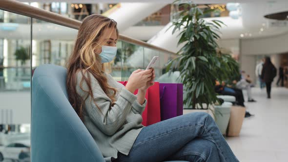 Caucasian Woman Buyer Wearing Medical Mask Relaxed with Shopping Bags Female Ill Shopper Sitting