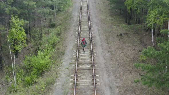 Woman with Backpack Walking in a Forest Along Railway Road - Aerial View.