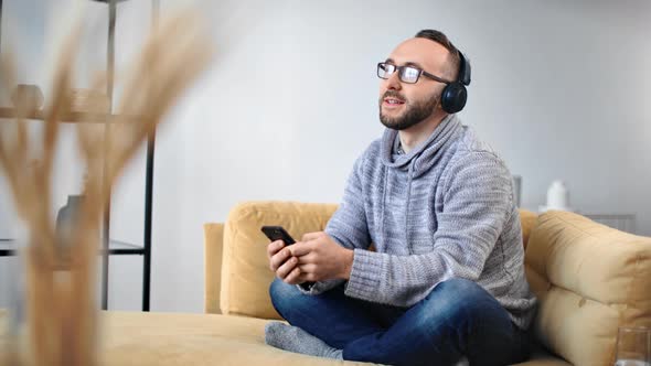 Cheerful Bearded Man in Headphones Listen Music Smartphone Application
