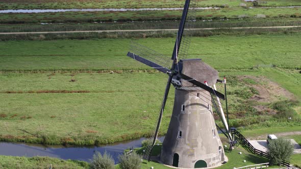 Drone fly by iconic rural Dutch windmill zooming in on black metal blades